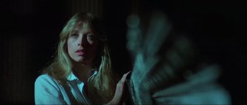 Movie still from “The House by the Cemetery” (1981), directed by Lucio Fulci – A woman with long blonde hair is looking at the camera; Close Up shot, Low angle