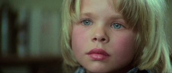 Movie still from “The House by the Cemetery” (1981), directed by Lucio Fulci – A young child's face with blue eyes; Close Up shot, High angle
