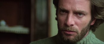 Movie still from “The House by the Cemetery” (1981), directed by Lucio Fulci – A person with a beard looking at the camera; Close Up shot, Low angle