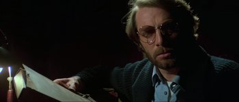 Movie still from “The House by the Cemetery” (1981), directed by Lucio Fulci – A man with a beard wearing glasses and a sweater; Close Up shot, Low angle