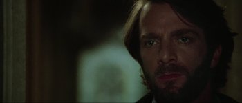 Movie still from “The House by the Cemetery” (1981), directed by Lucio Fulci – A person wearing a suit and tie; Close Up shot, Over the shoulder angle