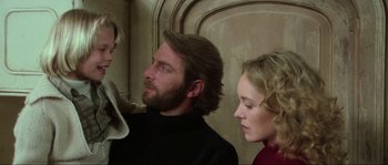 Movie still from “The House by the Cemetery” (1981), directed by Lucio Fulci – A man and two women standing next to each other; Close Up shot, Over the shoulder angle