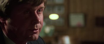 Movie still from “The House by the Cemetery” (1981), directed by Lucio Fulci – A man's face in a dark room; Close Up shot, Over the shoulder angle