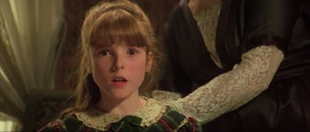 Movie still from “The House by the Cemetery” (1981), directed by Lucio Fulci – A little girl in a plaid dress looking at the camera; Close Up shot, High angle
