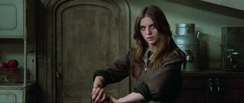 Movie still from “The House by the Cemetery” (1981), directed by Lucio Fulci – A woman in a brown shirt and a tie; Medium shot, High angle