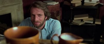 Movie still from “The House by the Cemetery” (1981), directed by Lucio Fulci – A person sitting in front of a table; Close Up shot, Over the shoulder angle