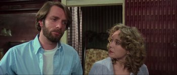 Movie still from “The House by the Cemetery” (1981), directed by Lucio Fulci – A man and a woman standing next to each other in a room; Close Up shot, Over the shoulder angle