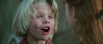 Movie still from “The House by the Cemetery” (1981), directed by Lucio Fulci – A young boy with blonde long hair and blue eyes; Close Up shot, Low angle