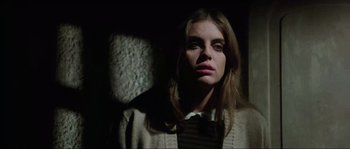 Movie still from “The House by the Cemetery” (1981), directed by Lucio Fulci – A young woman in a white shirt and a brown jacket; Close Up shot, Low angle