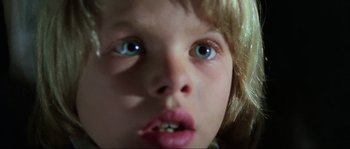 Movie still from “The House by the Cemetery” (1981), directed by Lucio Fulci – A young child's face with blue eyes; Extreme Close Up shot, Low angle