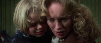Movie still from “The House by the Cemetery” (1981), directed by Lucio Fulci – A woman and a child looking down at each other; Close Up shot, Over the shoulder angle
