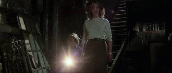 Movie still from “The House by the Cemetery” (1981), directed by Lucio Fulci – A woman and a child walking down a flight of stairs; Medium shot, Low angle