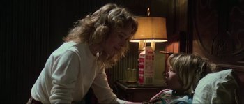 Movie still from “The House by the Cemetery” (1981), directed by Lucio Fulci – A woman and a child in a living room; Medium shot, Over the shoulder angle