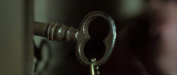 Movie still from “The House by the Cemetery” (1981), directed by Lucio Fulci – A key that is in the shape of a heart; Extreme Close Up shot, High angle