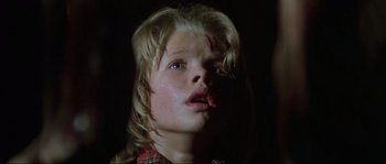 Movie still from “The House by the Cemetery” (1981), directed by Lucio Fulci – A young child with a knife stuck in his mouth; Close Up shot, Low angle