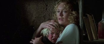 Movie still from “The House by the Cemetery” (1981), directed by Lucio Fulci – A woman holding a young boy in her arms; Close Up shot, Low angle