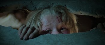 Movie still from “The House by the Cemetery” (1981), directed by Lucio Fulci – A woman with a knife stuck in her head; Close Up shot, Low angle