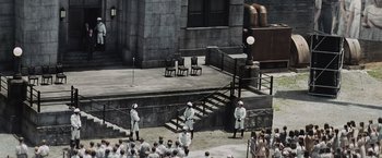 Movie still from “The Hunger Games” (2012), directed by Gary Ross – A group of people standing on steps in front of a building; Extreme Wide shot, High angle
