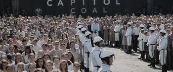 Movie still from “The Hunger Games” (2012), directed by Gary Ross – A large group of people standing next to each other in front of a building; Extreme Wide shot, High angle
