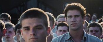 Movie still from “The Hunger Games” (2012), directed by Gary Ross – A group of men standing next to each other in a line; Close Up shot, Low angle