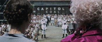 Movie still from “The Hunger Games” (2012), directed by Gary Ross – A group of people standing in front of a building; Extreme Wide shot, High angle