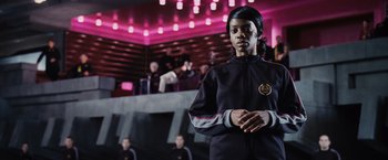 Movie still from “The Hunger Games” (2012), directed by Gary Ross – A person standing in front of a group of people; Medium shot, Low angle