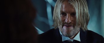 Movie still from “The Hunger Games” (2012), directed by Gary Ross – A person wearing a suit and tie; Close Up shot, Over the shoulder angle