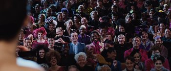 Movie still from “The Hunger Games” (2012), directed by Gary Ross – A group of people that are sitting in a room; Wide shot, High angle
