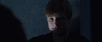 Movie still from “The Hunger Games” (2012), directed by Gary Ross – A young man is looking into the camera; Close Up shot, Low angle