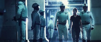 Movie still from “The Hunger Games” (2012), directed by Gary Ross – A group of men in white suits standing next to each other; Medium shot, Low angle