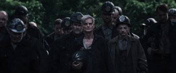 Movie still from “The Hunger Games” (2012), directed by Gary Ross – A group of men in black jackets and helmets; Medium shot, Low angle