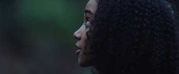 Movie still from “The Hunger Games” (2012), directed by Gary Ross – A person's face with trees in the background; Close Up shot, Low angle