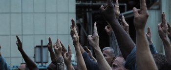 Movie still from “The Hunger Games” (2012), directed by Gary Ross – A group of people with their hands in the air; Medium shot, Low angle