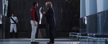 Movie still from “The Hunger Games” (2012), directed by Gary Ross – Two men talking to each other on a stage; Wide shot, Over the shoulder angle