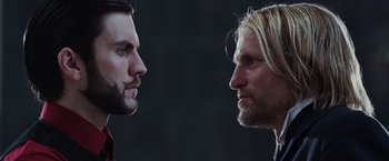 Movie still from “The Hunger Games” (2012), directed by Gary Ross – Two men facing each other in front of a building; Close Up shot, Low angle