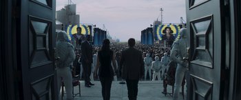 Movie still from “The Hunger Games: Catching Fire” (2013), directed by Francis Lawrence – A crowd of people standing in front of an audience; Wide shot, Over the shoulder angle