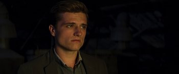 Movie still from “The Hunger Games: Catching Fire” (2013), directed by Francis Lawrence – A man in a suit looking at the camera; Close Up shot, Low angle