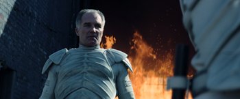 Movie still from “The Hunger Games: Catching Fire” (2013), directed by Francis Lawrence – A man wearing a suit of armor standing in front of a fire; Close Up shot, Low angle