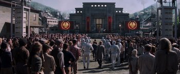 Movie still from “The Hunger Games: Catching Fire” (2013), directed by Francis Lawrence – A group of people standing in front of a building; Extreme Wide shot, High angle