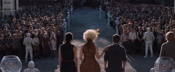Movie still from “The Hunger Games: Catching Fire” (2013), directed by Francis Lawrence – A group of people standing in front of a crowd; Wide shot, High angle