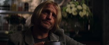 Movie still from “The Hunger Games: Catching Fire” (2013), directed by Francis Lawrence – A person holding a cup of coffee; Close Up shot, Over the shoulder angle