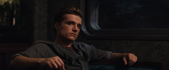 Movie still from “The Hunger Games: Catching Fire” (2013), directed by Francis Lawrence – A man sitting on a couch in a dark room; Close Up shot, Low angle