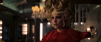 Movie still from “The Hunger Games: Catching Fire” (2013), directed by Francis Lawrence – A woman in a red dress with a blonde wig on her head; Close Up shot, Low angle