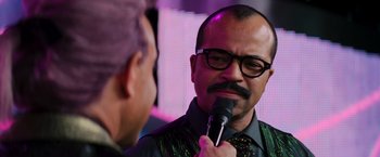 Movie still from “The Hunger Games: Catching Fire” (2013), directed by Francis Lawrence – A man with a microphone talking to another man; Close Up shot, Over the shoulder angle