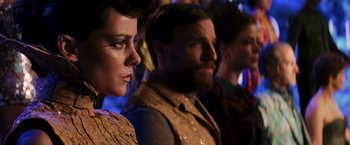 Movie still from “The Hunger Games: Catching Fire” (2013), directed by Francis Lawrence – A group of people standing next to each other in a room; Close Up shot, Over the shoulder angle