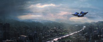 Movie still from “The Hunger Games: Catching Fire” (2013), directed by Francis Lawrence – An aerial view of a large city with mountains in the background; Extreme Wide shot, High angle