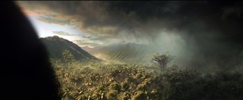 Movie still from “The Hunger Games: Catching Fire” (2013), directed by Francis Lawrence – A tree in the middle of a lush green field; Extreme Wide shot, High angle