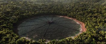Movie still from “The Hunger Games: Catching Fire” (2013), directed by Francis Lawrence – An aerial view of a large body of water surrounded by trees; Extreme Wide shot, High angle