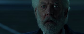 Movie still from “The Hunger Games: Catching Fire” (2013), directed by Francis Lawrence – An old man with a white beard stares at the camera; Close Up shot, Low angle