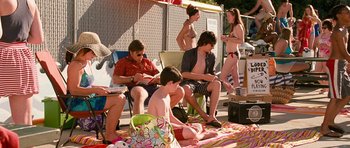Movie still from “Diary of a Wimpy Kid: Dog Days” (2012), directed by David Bowers – A group of people sitting on a blanket on the ground; Wide shot, High angle
